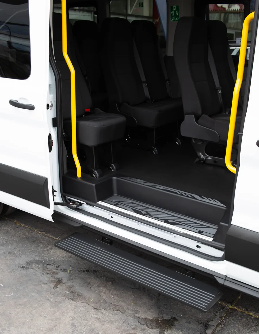 Puerta corredera abierta de la Ford Transit de Klauza, con pasamanos amarillos y peldaño